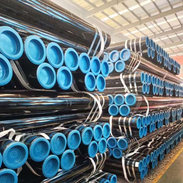 Warehouse stacks of carbon steel pipe bundled with steel strapping and fitted with blue plastic end caps